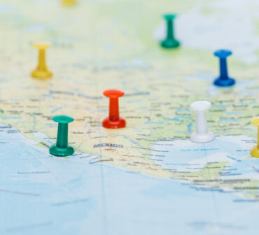 Map of North America marked with colored push pins across multiple cities.